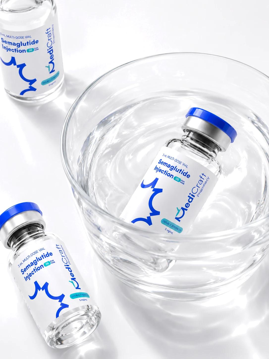 Two MediCraft semaglutide vials beside a glass of water