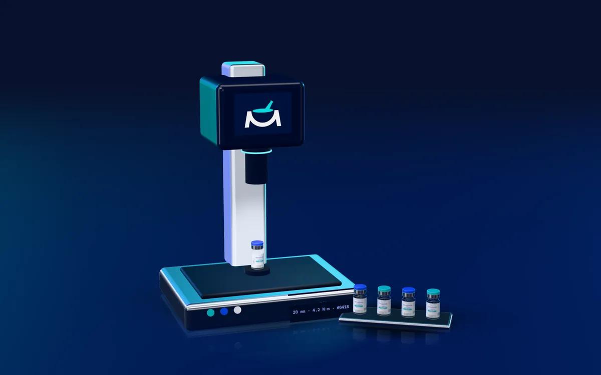Rendering of an automated vial crimper sealing a MediCraft vial, with crimped vials on a tray