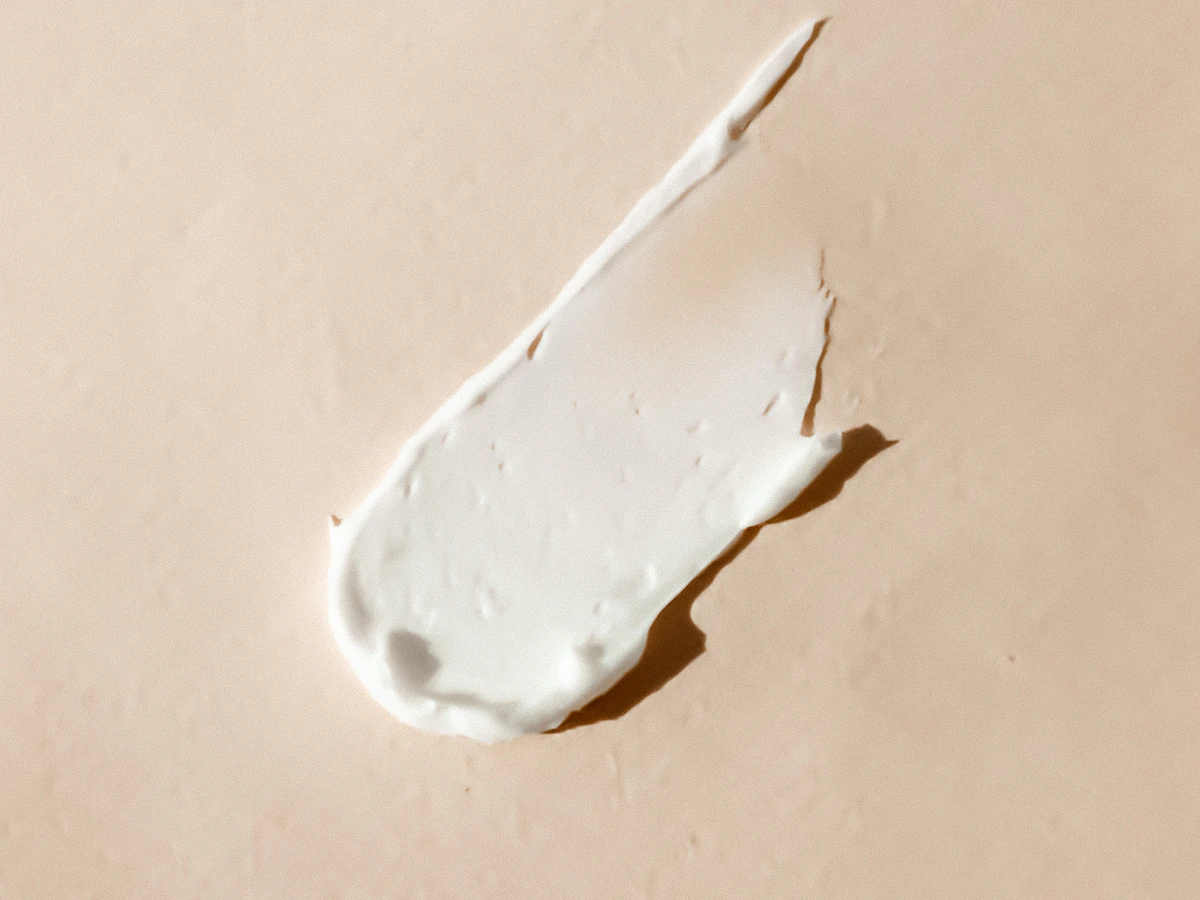A swatch of white cream on a peach surface